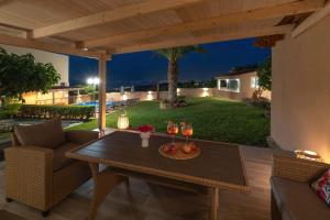 un patio con una mesa con copas de vino. en Villa Aretousa 1, en Agia Marina de Nea Kydonia 42 fotos más