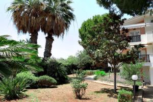 a garden in front of a building with palm trees at Ekatis Seacoast Nest in Livanates