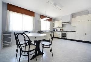 a white kitchen with a table and chairs in it at Enorme TRIPLEX en el centro de O Grove in O Grove