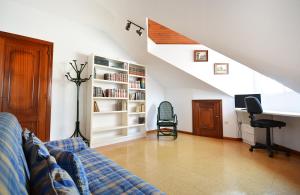 a living room with a couch and a book shelf at Enorme TRIPLEX en el centro de O Grove in O Grove