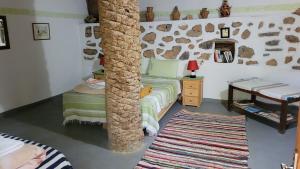 a room with a bed and a pole in it at Tigmi Bulbul in Id AÃ¯ssa