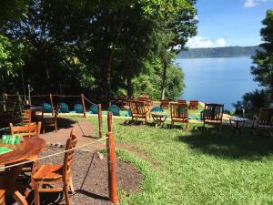 een groep tafels en stoelen naast een meer bij Laguna Beach Club in La Laguna