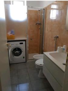 a bathroom with a toilet sink and a washing machine at Appartamento in residence a Campomarino di Maruggio in Maruggio