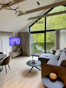 a living room with a couch and a tv at LEX apartments in Palanga