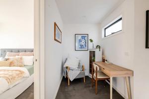 a bedroom with a bed and a desk and a table at Stunning, modern, two-story detached townhouse in Melbourne