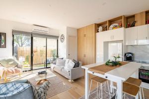 a kitchen and living room with a table and chairs at Stunning, modern, two-story detached townhouse in Melbourne