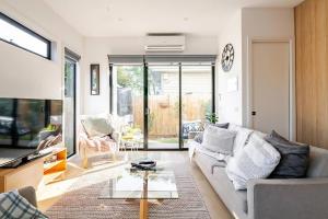 a living room with a couch and a table at Stunning, modern, two-story detached townhouse in Melbourne