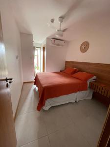 a bedroom with a bed with a red blanket on it at Imperia Lounge Itacimirim in Camacari +47 photos