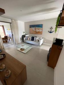 a living room with a couch and a table at Imperia Lounge Itacimirim in Camacari