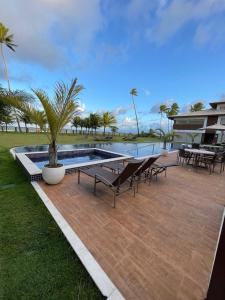 a patio with a pool and chairs and a house at Imperia Lounge Itacimirim in Camacari