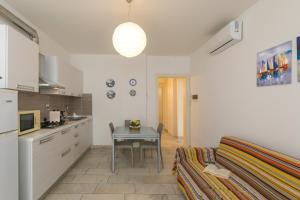 eine Küche mit einem Tisch und einem kleinen Tisch mit einem Sofa in der Unterkunft Villa Corallo Sofia in San Vincenzo