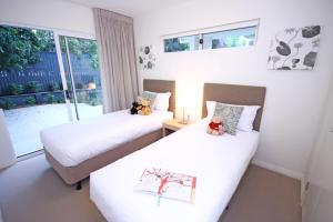 a hotel room with two beds and two lamps at Domain Serviced Apartments in Brisbane