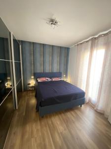 a bedroom with a blue bed and a ceiling fan at M&C House in Ponterotto