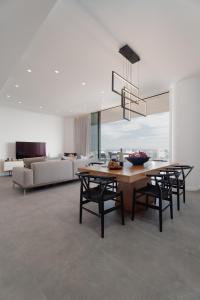 a dining room with a table and chairs and a couch at Protaras Eden Seaside Suite in Protaras