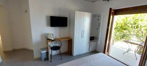a bedroom with a bed and a television and a window at ArteMare B&B in Diamante