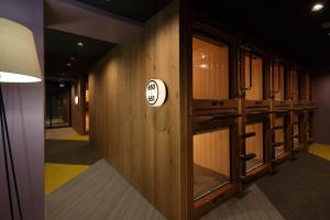 a hallway with wooden cabinets and a sign on a wall at Booth Netcafe & Capsule in Tokyo