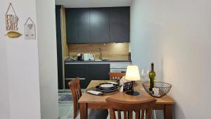 a kitchen with a wooden table with chairs and a bottle of wine at Superb 1 bedroom in the best zone of the city. in Ferizaj