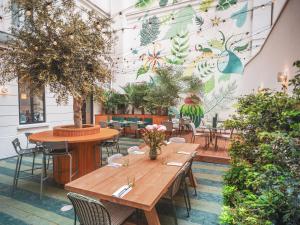 a restaurant with tables and chairs and a wall with plants at Hôtel Belleval in Paris