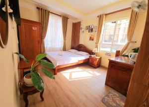una camera con un letto e una pianta di Bình Đào Hotel - Khách sạn ngay trung tâm giá rẻ a Da Lat