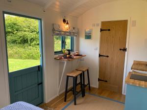 a small kitchen with a counter and a door at St. Kew Shepherd Huts in Wadebridge