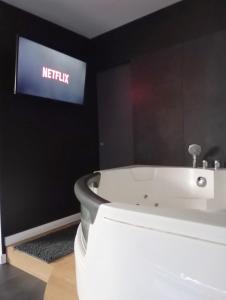 a white bath tub in a room with a sign at Balnéo SPA Allevard in Allevard +1 photo