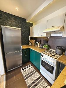 a kitchen with green cabinets and a stainless steel refrigerator at Apartament Błękitny Horyzont in Kędzierzyn-Koźle +11 photos