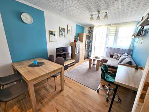 a living room with a table and a couch at Apartament Błękitny Horyzont in Kędzierzyn-Koźle