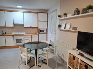 a kitchen with a table and chairs in a kitchen at Apartamento Arriondas in Arriondas