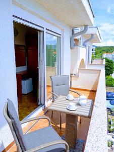 a patio with a table and chairs on a balcony at Rooms Helena in Krk