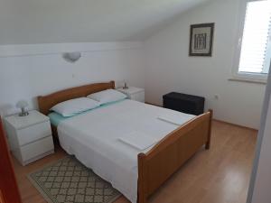 a bedroom with a large bed and two night stands at Apartments "Mulo" beachfront in Vrsi