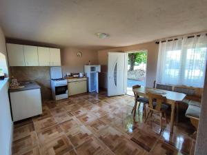 a kitchen with a wooden floor and a kitchen with a table at Carlitos in Gospić