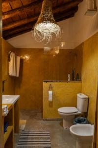 a bathroom with a toilet and a sink and a chandelier at Cortijo Los Llanos in Huéscar
