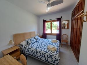 ein Schlafzimmer mit einem Bett und einem Tisch und einem Fenster in der Unterkunft Casa en Viladamat con piscina en la Costa Brava in Viladamat