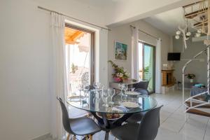 a dining room with a glass table and chairs at Navarino Golden sunset Apartment in Pylos
