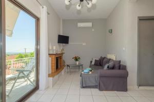 a living room with a couch and a balcony at Golden Navarino's Sunset in Pylos
