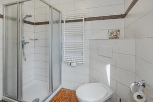 コルスヴァントにあるHaus Inesのトイレとシャワー付きの白いバスルーム +5枚の写真