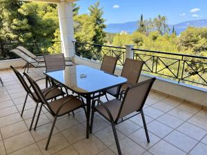 a table and chairs on a balcony with a view at The Theologos Guesthouse in Theologos
