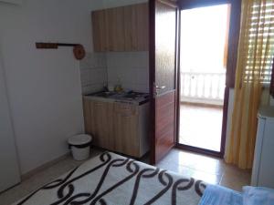 a kitchen with a sink and a door to a patio at Apartment Tereza in Sukošan +1 photo