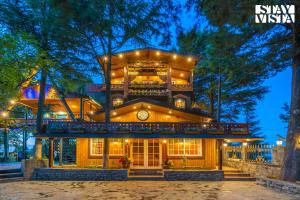 a large house with lights on it at night at Chalet Rushli - Free Breakfast with Valley View at Mussoorie by StayVista in Kanatal