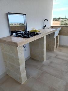 a stone table with a laptop on top of it at Mandulivi, chalet nel mandorleto e mansarda vista mare in Villaggio Azzurro +14 photos