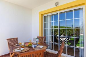 a dining room with a table and chairs and a window at Seasun Step Apartment in Praia da Rocha in Portimão