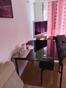 a living room with a glass table and a television at Apartment Victory Second in Pomorie