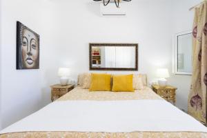 a white bedroom with a large bed with yellow pillows at Atlantic Dream with pool II in Puerto de Santiago +39 photos