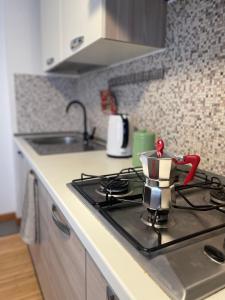 a stove top with a tea pot on top of it at Fonderia's Home - Parcheggia Senza Pensieri! in Treviso +8 photos