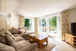 a living room with a couch and a tv at Trewhiddle Retreat V27 by Together Travel - Luxury 3-Bedroom Villa in St Austell
