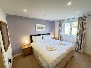 a bedroom with a bed with two towels on it at Trewhiddle Retreat V27 by Together Travel - Luxury 3-Bedroom Villa in St Austell