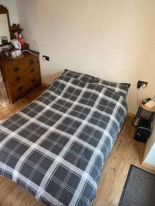 a bed with a black and white plaid comforter in a bedroom at The old wash house in Denver