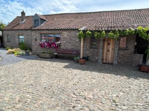 Una casa de ladrillo con un banco delante de ella. en CasaDeKaMa, en Evergem