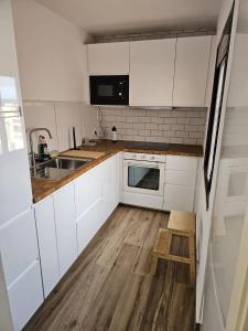 a kitchen with white cabinets and a wooden floor at Ático Alameda in Santa Cruz de la Palma