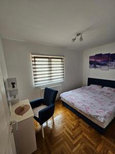 Un dormitorio con una cama y una silla y una ventana. en Jovana stan na dan Pale, en Pale